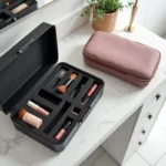 Comparaison entre une vanity case rigide noire et une vanity case souple rose avec produits cosmétiques sur marbre blanc