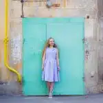woman standing against teal door